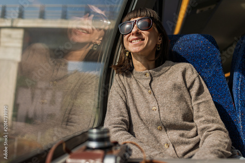 A train journey. A young woman rides on a train, admiring the beautiful scenery and gazing thoughtfully out the window.