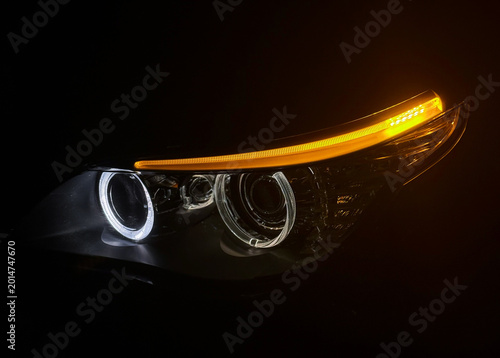 Fotografie BI-LED headlights of a modern and expensive black car, hood and radiator grille