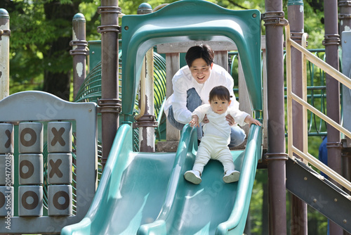 Foto すべり台で遊ぶ若い父親と小さい娘