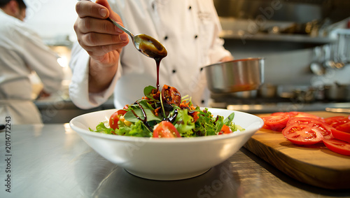 Chef dressing a fresh salad