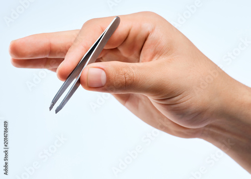 Tableau sur toile Person, hand or grooming with tweezer for styling, hair removal or beauty on a studio background
