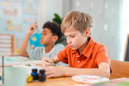 Foto Back to school and education concept of young boy studying in classroom with cla