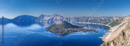 Photos Deep blue Crater Lake surrounded by steep volcanic caldera cliffs with Wizard Is