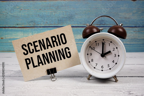 Scenario Planning text written on paper card with alarm clock on wooden background