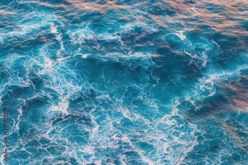 Top View of Turquoise Ocean Water Texture with White Foam and Ripples Sea surface nature background