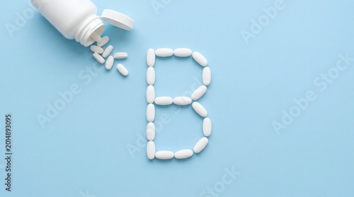 Vitamin B Pills Forming the Letter B on a Blue Background.