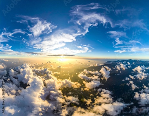 sunrise above cloudscape with distant mountain range aerial panoramic golden hour