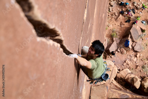 Vászonkép Rock climber crack climbing sandstone wall with determination