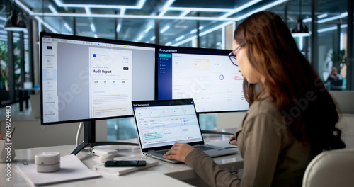 Tableau sur toile Young Woman Uses Laptop To Analyze Risk