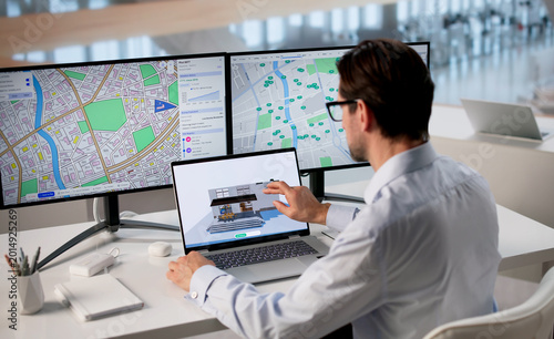 Фотография Man Using Laptop To Design Sustainable Heating System