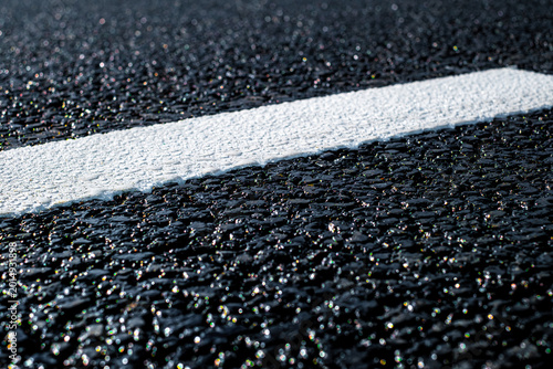 Detailed view of asphalt with freshly applied thermoplastic road marking