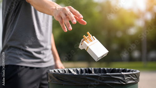 Person Throwing Cigarette Pack into Trash Bin Outdoors Representing Smoking Cessation Healthy Choices and Tobacco Free Lifestyle