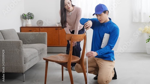 若い女性の引っ越しの見積もりをする若い業者　ライフスタイルイメージ	
