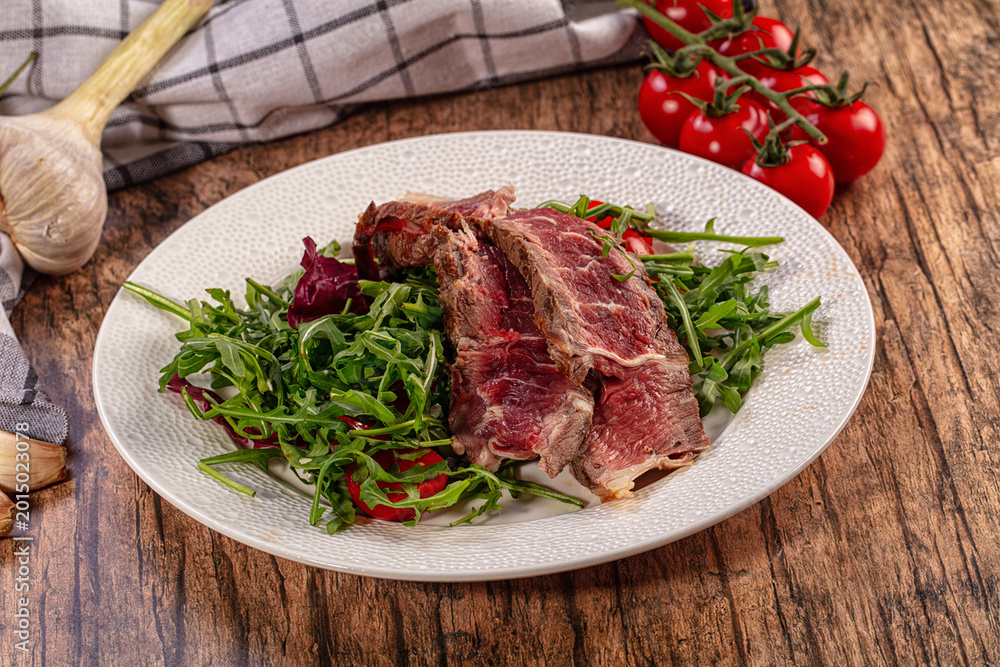 Fototapeta premium Gourmet Roast Beef Slices Fresh Arugula Salad Cherry Tomatoes Garlic Chili Pepper