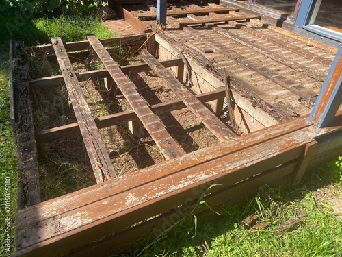 Rotted wood deck boards decayed timber caused by fungi thriving in damp conditions, represent a significant structural risk, house renovations project.