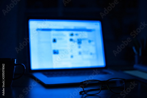 Eyeglasses on Desk in Front of Glowing Laptop Screen at Night Digital Eye Strain Concept