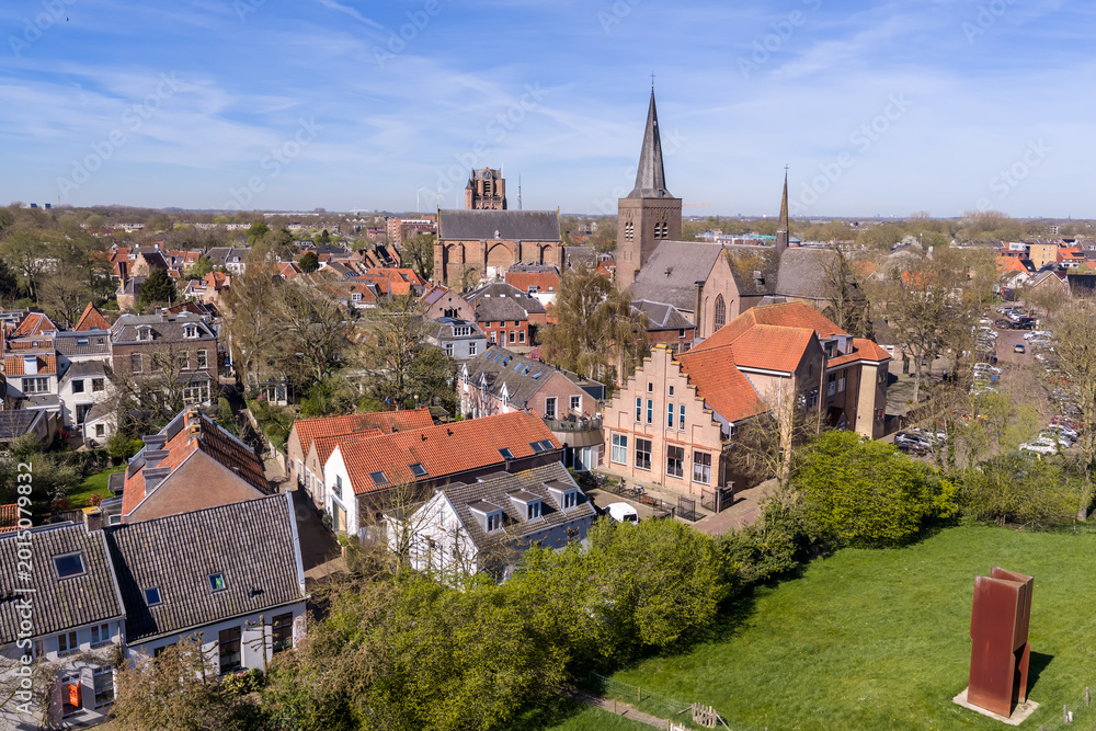 Obraz premium Aerial view of the historic core of Wijk bij Duurstede with Gothic Grote Kerk tower and Sint-Johannes spire above red-tiled roofs, Netherlands