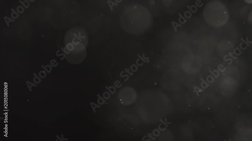 Slow motion real dust particles floating mid air over dark background