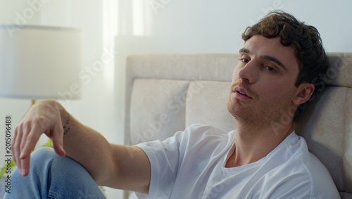 Fotografie Thoughtful pensive Caucasian man lying bed in bedroom home tired upset male bore