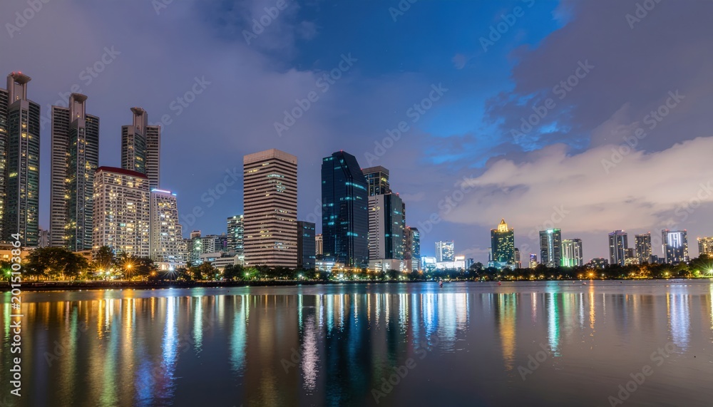 Obraz premium Modern City Skyline Reflected in Calm Water at Dusk.