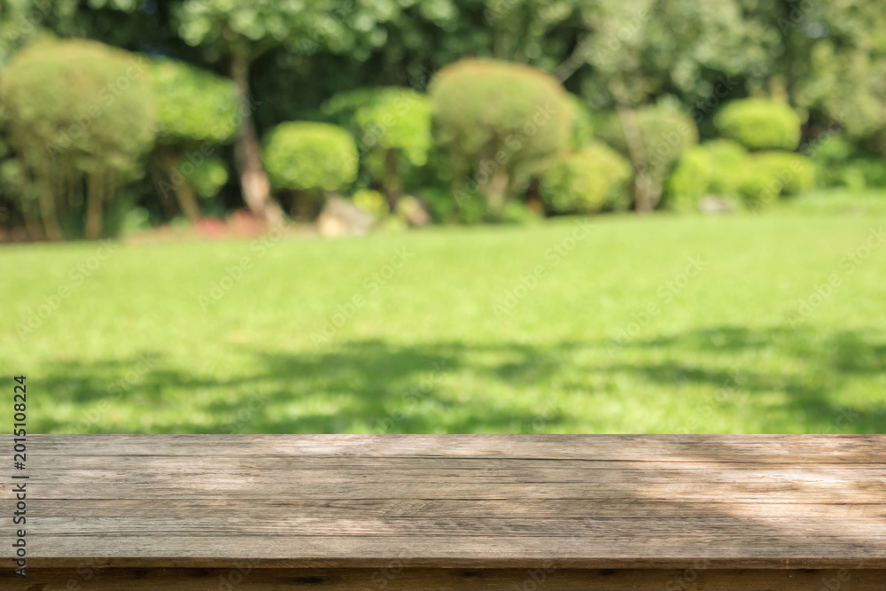 Fototapeta premium Empty wood table top with abstract blur park garden background