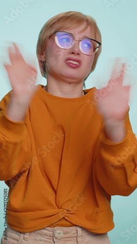 Dont want to look at this, awful. Afraid attractive woman closing eyes with hand showing stop gesture, confused shy scared to watch. Young lady isolated on blue studio background. People lifestyles