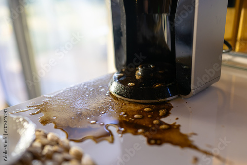 Foto Spilled coffee around coffee maker on kitchen counter during morning preparation