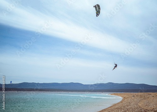Golden Horn Beach, Brac Island, Croatia: Kitesurfer jumping in the air over a beach and ocean