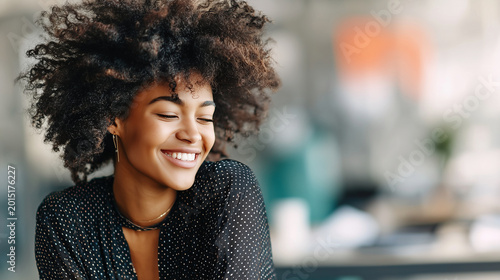 Spontaneous candid close up of woman laughing softly, blurred office background