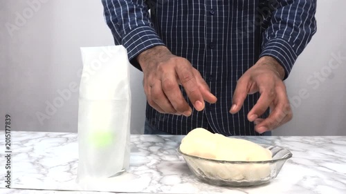 Person Showing Dough in Glass Bowl with Paper Bag on Marble Counter, Cooking or Baking Concept, A person presenting fresh, raw dough in a clear glass bowl on a marble countertop