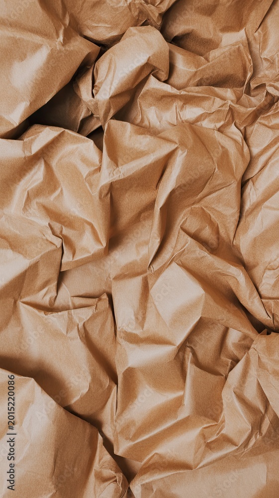 Obraz premium Crumpled brown paper texture, abstract background, natural material surface, wrinkled kraft paper, decorative texture, modern design element, realistic detailed pattern.