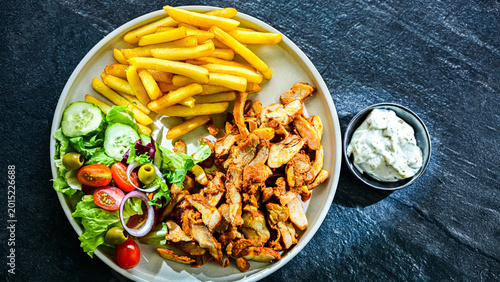 Kebab served with french fries and vegetables