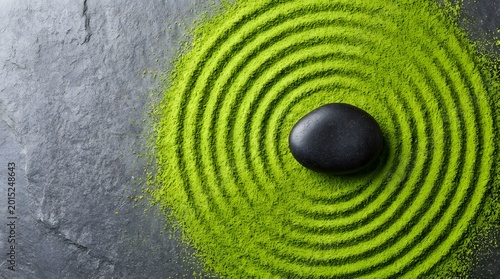Minimalist Zen Garden Concept Made of Green Matcha Powder with Black River Stone for Mindfulness and Wellness