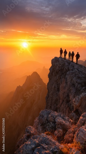 A group of hikers silhouetted against a vibrant sunset over rugged mountain peaks