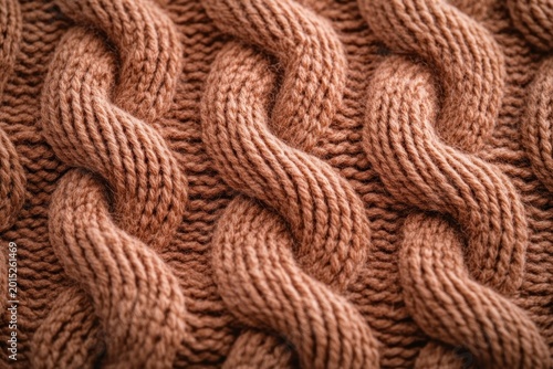 close-up of warm brown chunky cable knit sweater fabric with thick braided stitches evoking cozy comforting warmth
