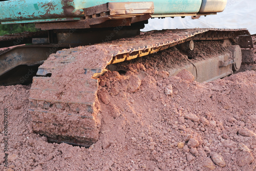 Fototapeta premium Excavator tracks in sand construction site equipment outdoor close-up machinery impact