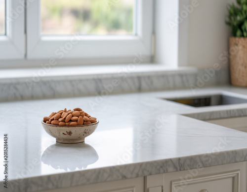 Rustic bowl of organic almonds sitting on a polished marble counter with reflections in a sunlit modern kitchen interior