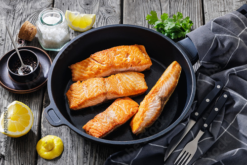 Pan-seared salmon fillets on a skillet, close-up