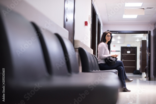 Woman waiting in a modern Middle Eastern eye hospital clinic corridor in Egypt before surgery