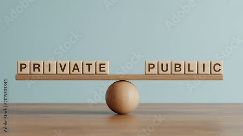 A wooden balance scale with blocks spelling private and public on either side