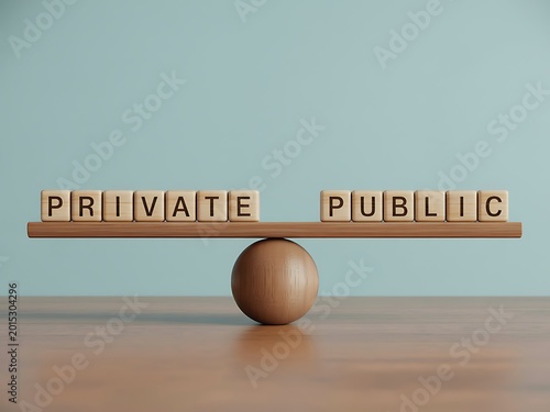A wooden seesaw with blocks spelling private and public on a table