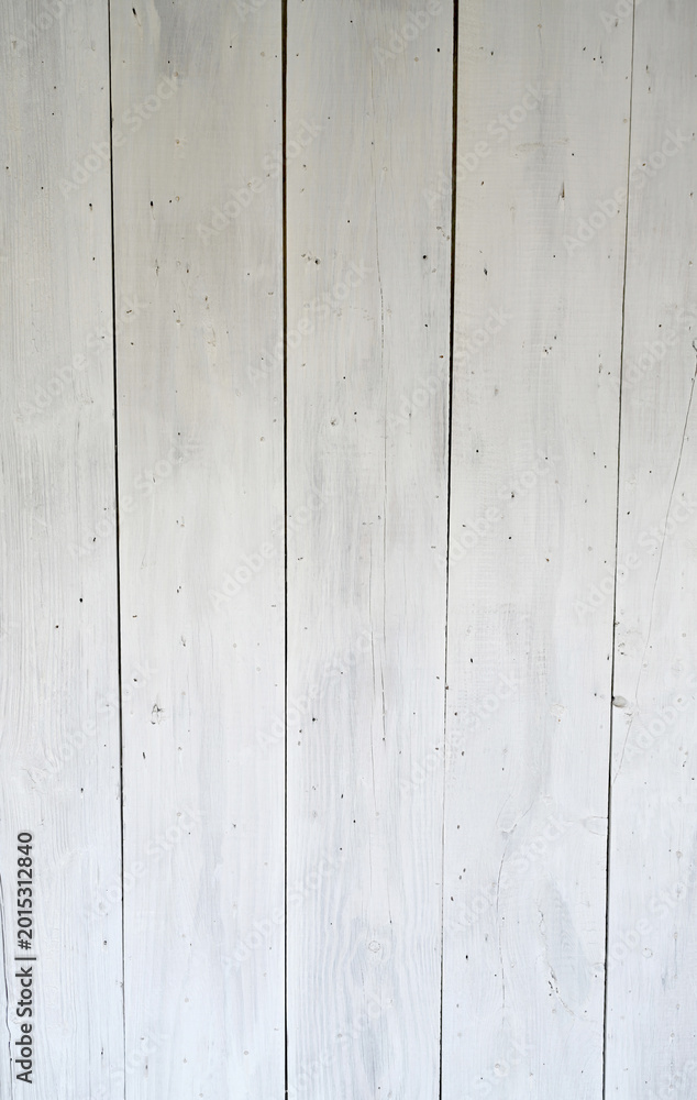 Obraz premium Weathered white wash painted board surface with vertical boards showing worn paint, visible wood grain, knots, cracks, gaps between boards, many nail heads, and light shadow at the top