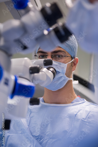 Bild auf Leinwand Middle Eastern eye surgeon performing delicate microsurgery in modern hospital o