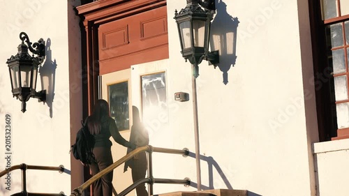Young Woman Walks Through Door of Building
