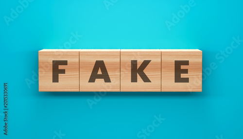 Foto Fake Blocks: Four wooden blocks spelling out the word FAKE, offering a conceptual representation of deception or falsehood, set against a calm blue backdrop