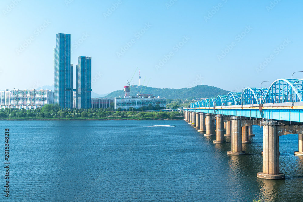 Fototapeta premium Seoul, South Korea - Mar. 01, 2026 : Scenic View of Dongjak Bridge over Han River with Namsan Seoul Tower under Clear Blue Sky in Spring 