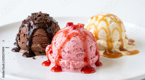 Tableau sur toile Gourmet dessert presentation of three ice cream scoops topped with rich chocolat