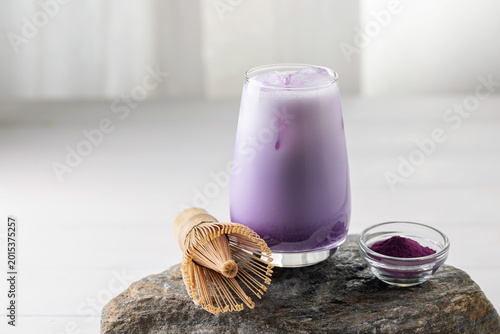 Ube latte in glass. Healthy vegan drink. Viral trendy asian beverage