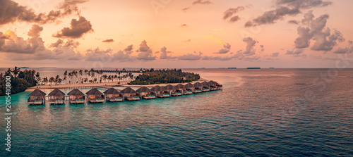 Quadro su tela Breathtaking aerial view of Maldives water villas at sunset over a peaceful ocea