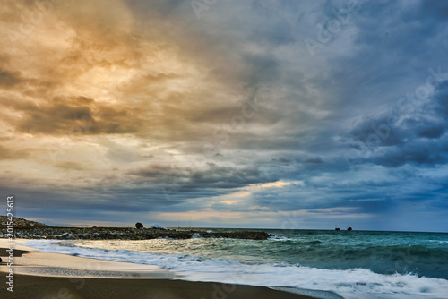 Moody sky over beach with rolling ocean waves